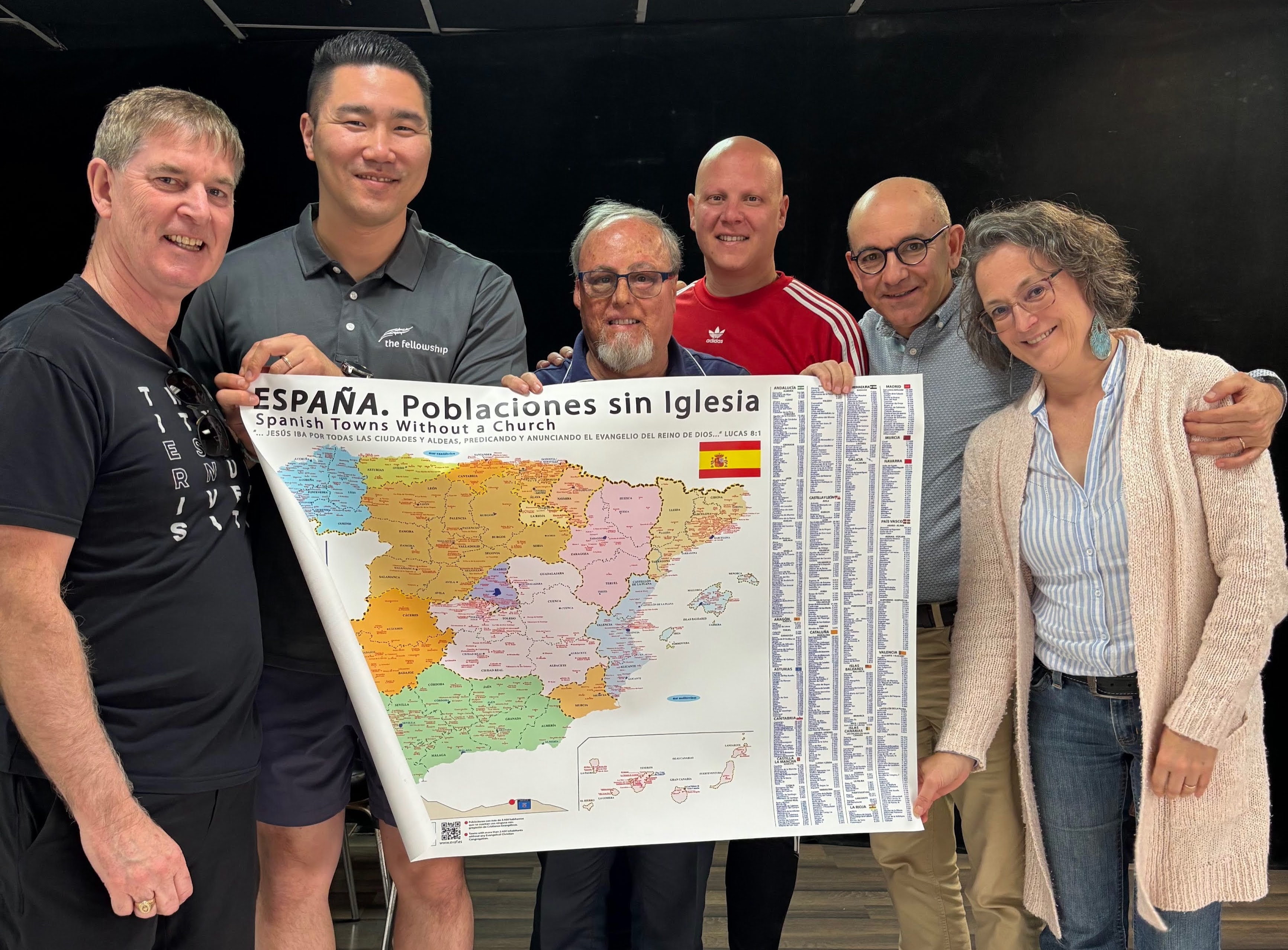 Byron Chae and the Coalition 1700 team holding a map of Spanish towns without a church in Seville, Spain